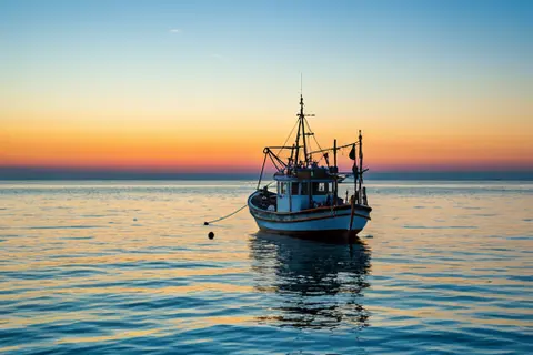 Traditional fishing boat on the sea at sunrise